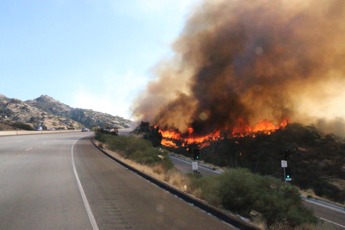 #RockyPeak #118Freeway Mile Long Fire, 50-75 acres shuts down both sides of road.Helitankers and CL415 Superscoopers make water drops at 75 to 100 feet. Reporter and News truck got a bath. 25 engines deploy to protect homes below freeway, none damaged. @KNX1070   