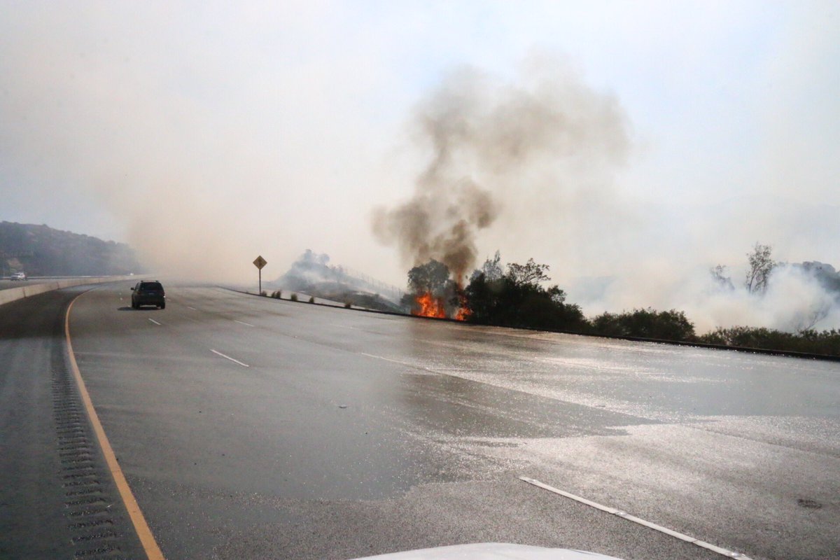 #RockyPeak #118Freeway Mile Long Fire, 50-75 acres shuts down both sides of road.Helitankers and CL415 Superscoopers make water drops at 75 to 100 feet. Reporter and News truck got a bath. 25 engines deploy to protect homes below freeway, none damaged. @KNX1070   