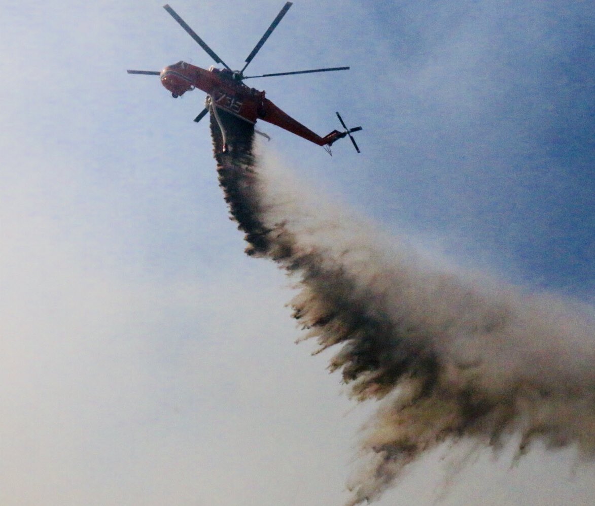 #RockyPeak #118Freeway Mile Long Fire, 50-75 acres shuts down both sides of road.Helitankers and CL415 Superscoopers make water drops at 75 to 100 feet. Reporter and News truck got a bath. 25 engines deploy to protect homes below freeway, none damaged. @KNX1070   