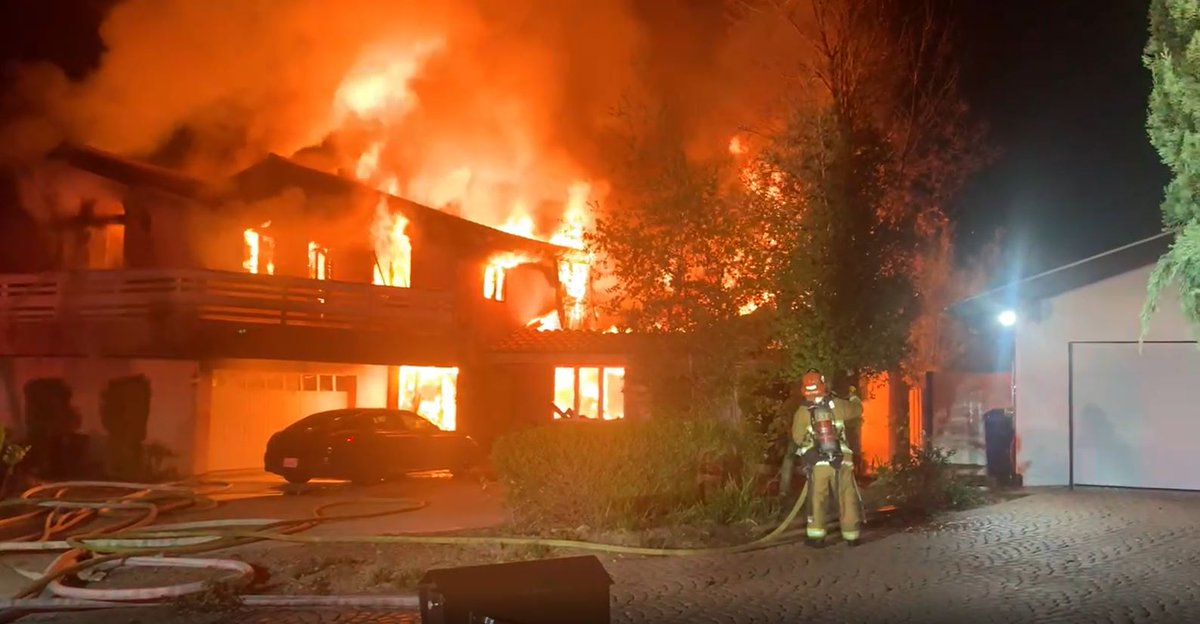 Firefighters early Monday morning battled a large fire which tore through a Tarzana home