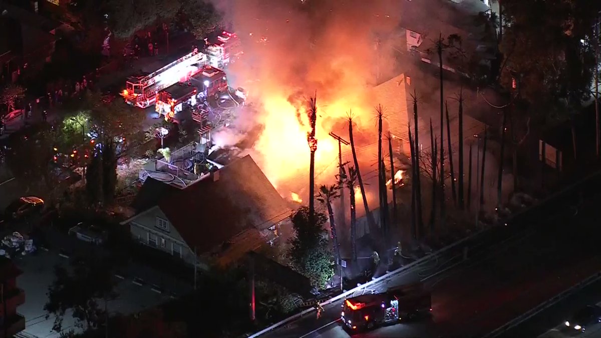 @LAFD crews are working to contain a house fire that spread to trees in the Harvard Heights area.