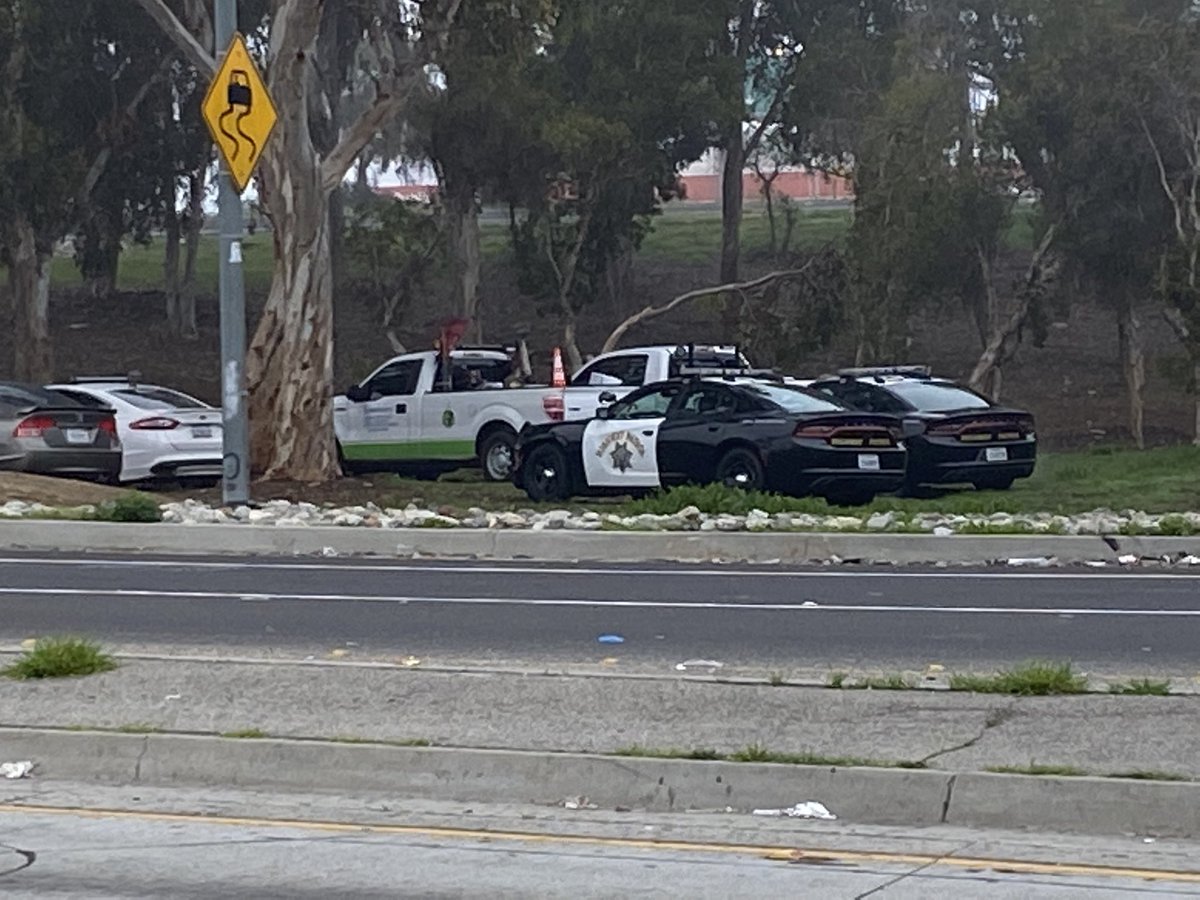 Cleanup crews & CHP officers have arrived here at Century &amp; the 405 to cleanup a homeless camp next to the freeway.  Critics think the cleanup is aimed at hiding the homeless problem from fans who are coming to the SuperBowl