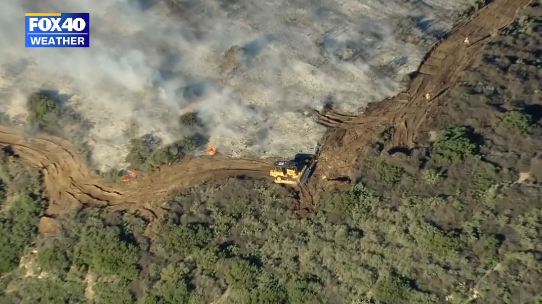 Firefighters working on creating a firebreak to halt the spread of the Emerald Fire towards the populated coastline