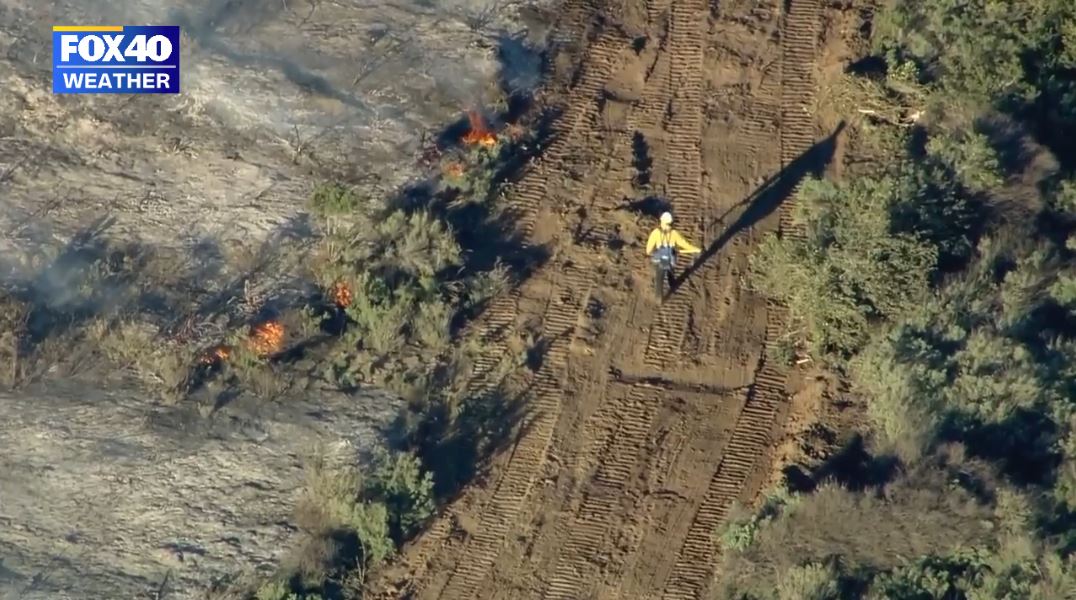 Firefighters working on creating a firebreak to halt the spread of the Emerald Fire towards the populated coastline