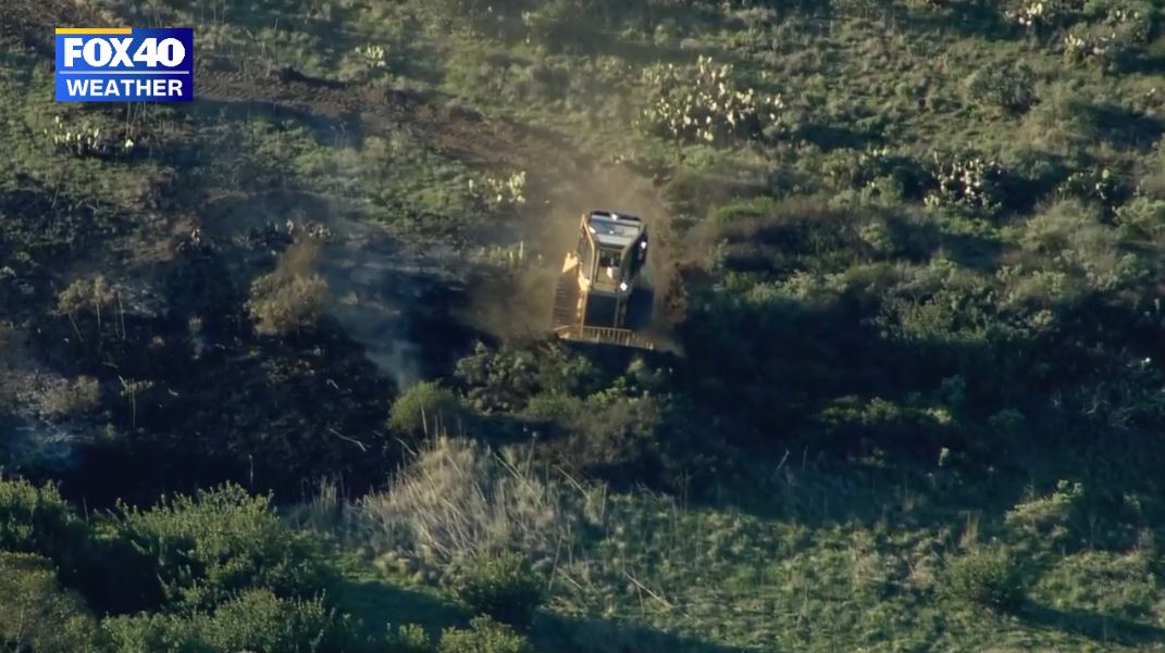 Firefighters working on creating a firebreak to halt the spread of the Emerald Fire towards the populated coastline