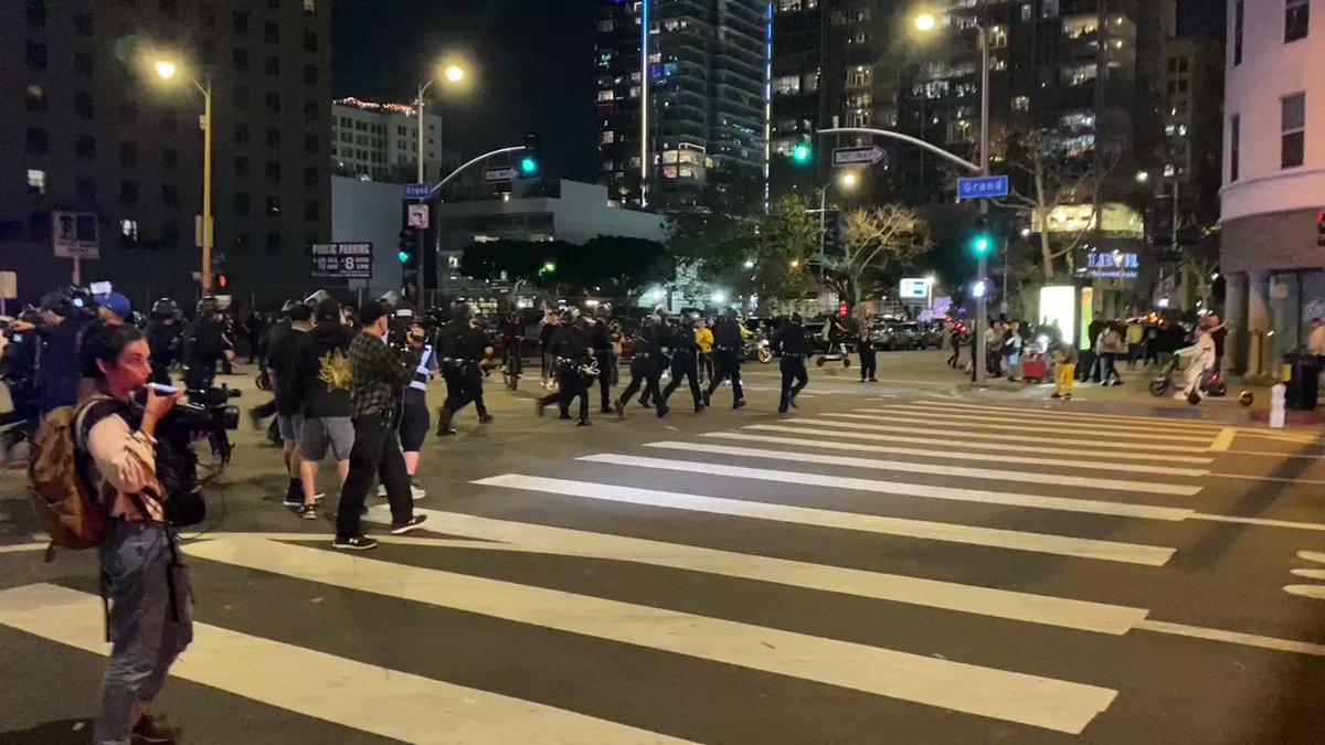 Large numbers of LAPD officers slowly surrounding intersection of 9th and Grand — then rushed ahead to move people east