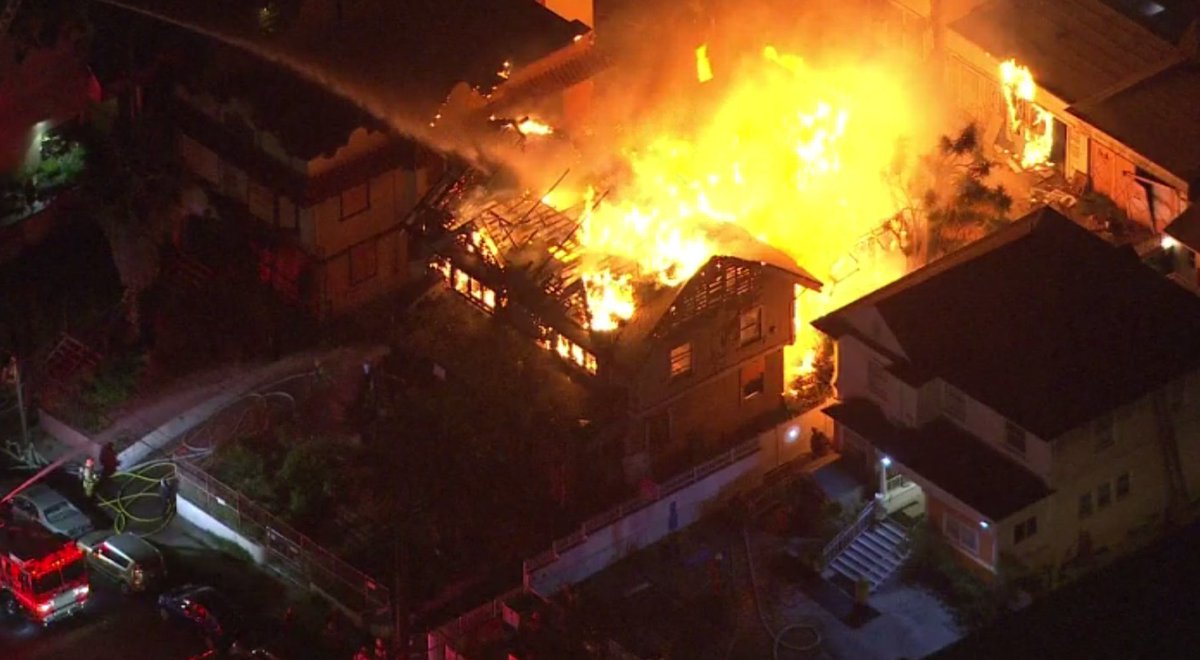 The blaze at the vacant two-story Craftsman in the Westlake District is threatening nearby structures