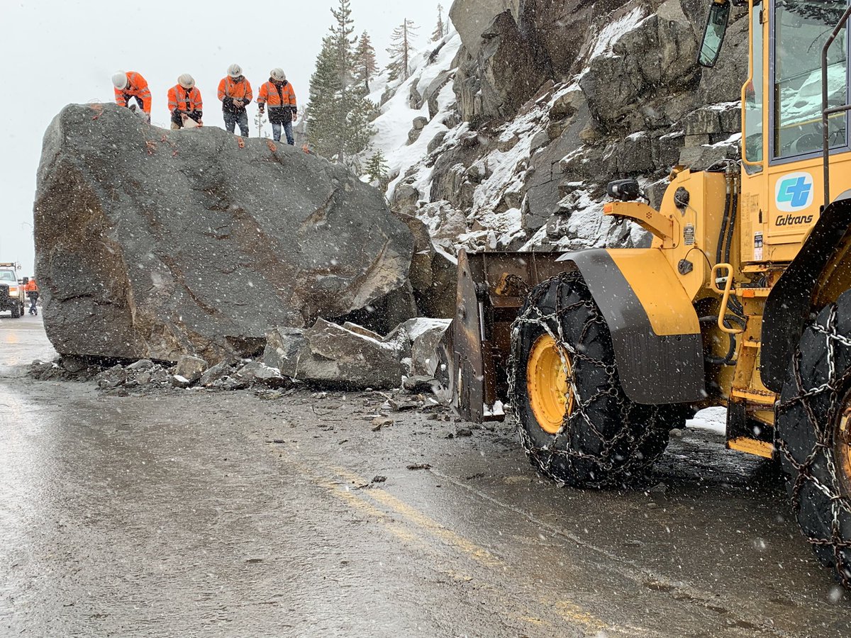 Working amid snow flurries, Caltrans crews packing explosives in giant boulder blocking US 50 on Echo Summit in the Lake Tahoe area. Roadway remains closed with no ETO.