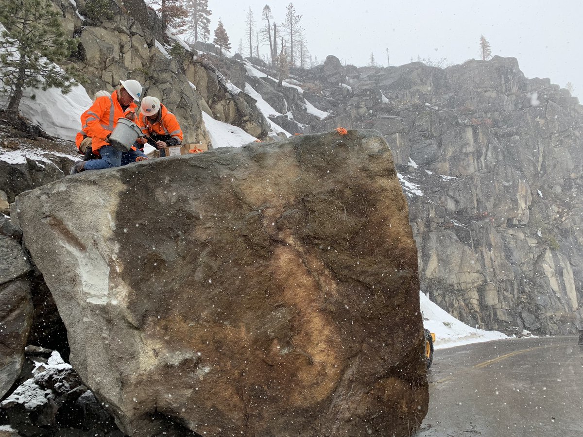 Working amid snow flurries, Caltrans crews packing explosives in giant boulder blocking US 50 on Echo Summit in the Lake Tahoe area. Roadway remains closed with no ETO.
