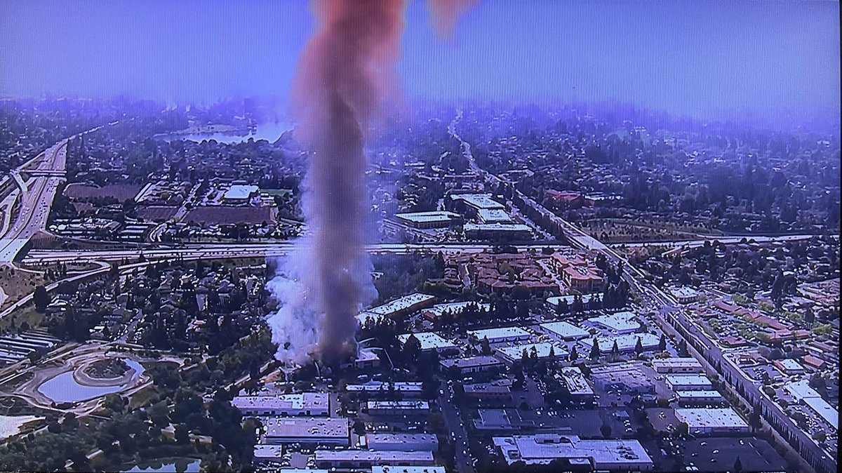 Likely will see smoke impacts into the evening as parts of the commercial structure remain well involved, fire crews applying water via ladder trucks