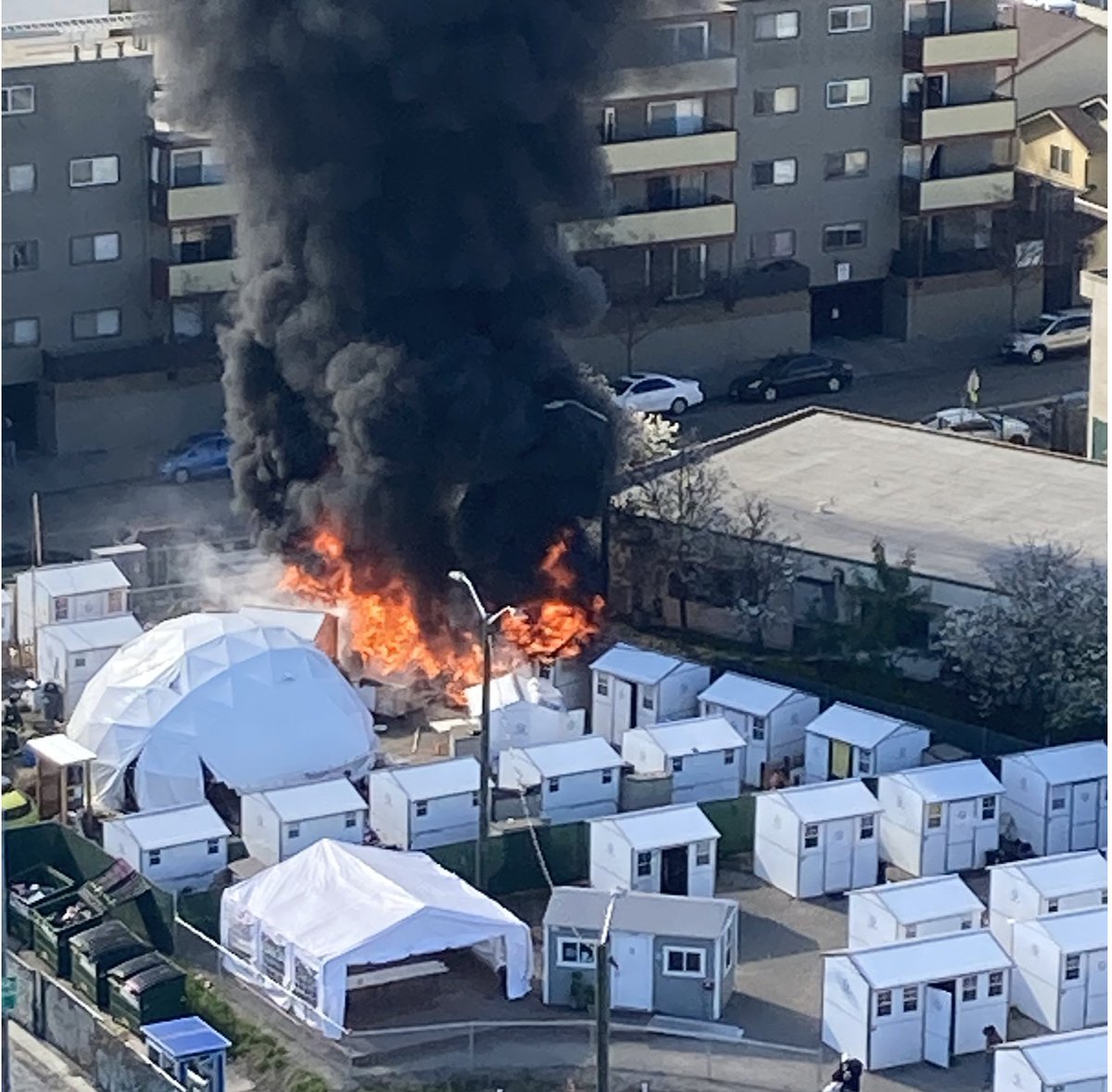 Large explosion (BOOOOOM.) followed by a large fireball, black smoke, and lots of smaller explosions (POP POP POP) during the ensuing fire at the tiny home village at E12th St and 2nd Ave (Oakland)