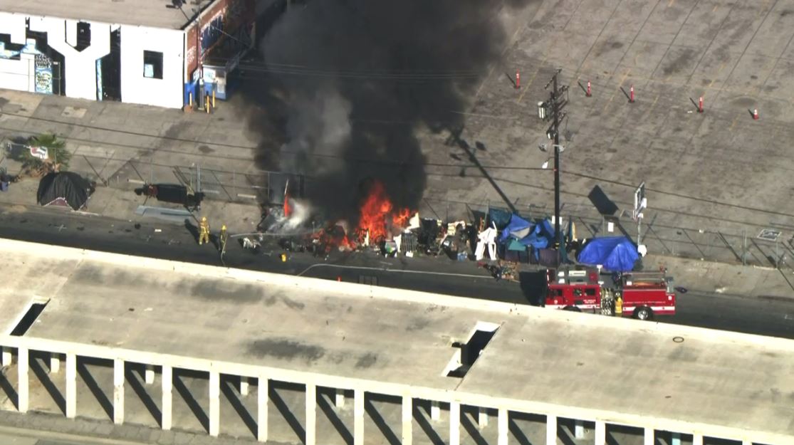 Crews battling a fire at a homeless encampment in the Fashion District of Downtown L.A. near San Julian St. and Olympic Blvd