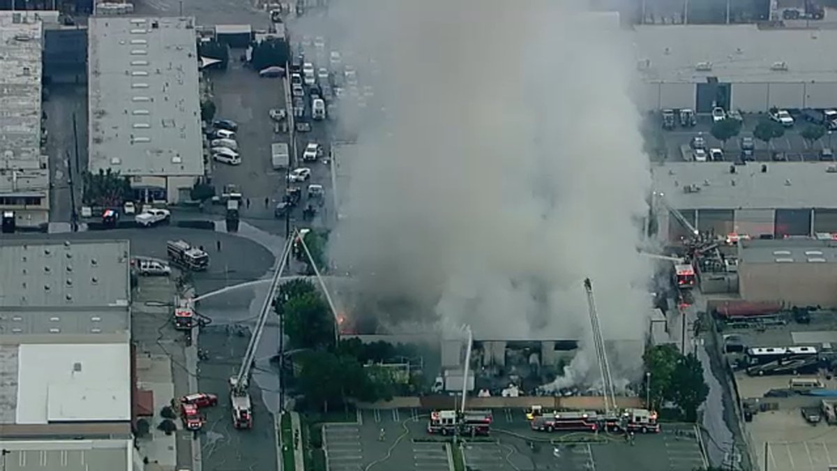 Large fire at commercial building in Los Alamitos area sending thick plume of smoke into air