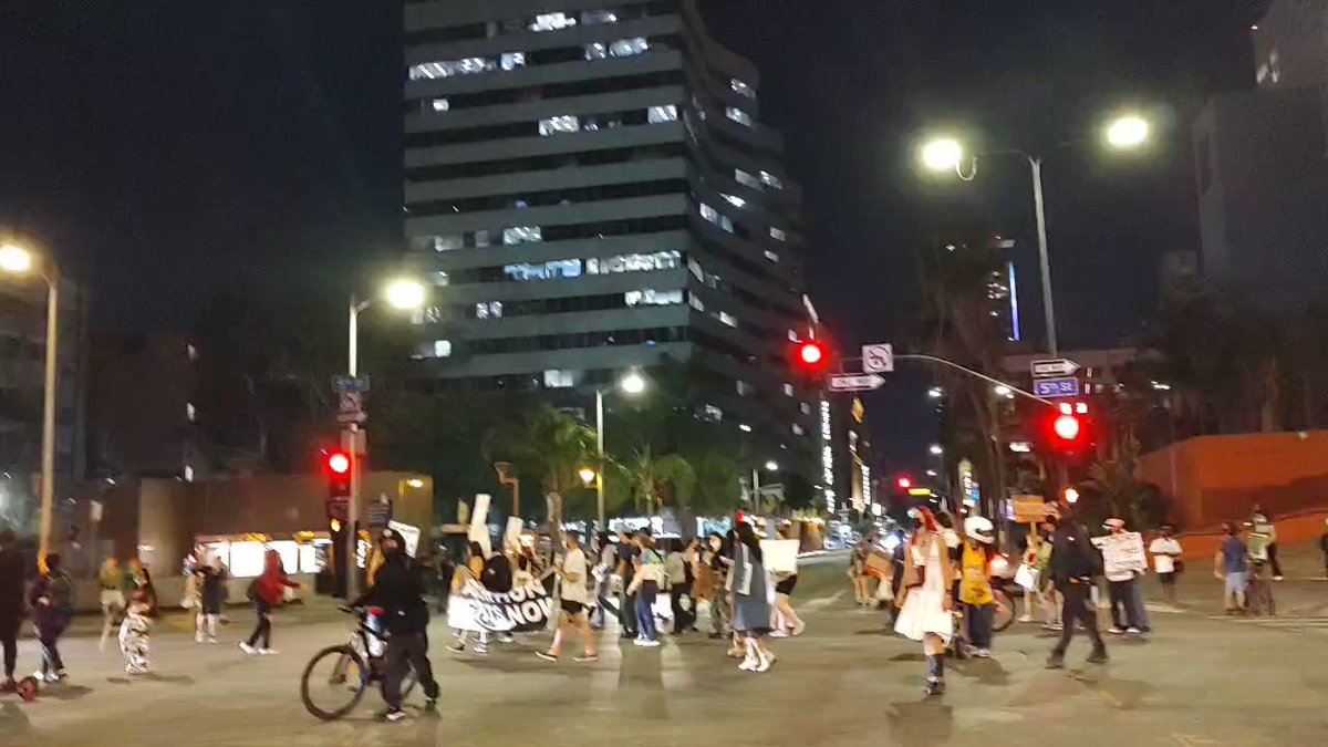 LAPD units with tactical gear exit their vehicles and face towards the abortion rights protesters holding the intersection