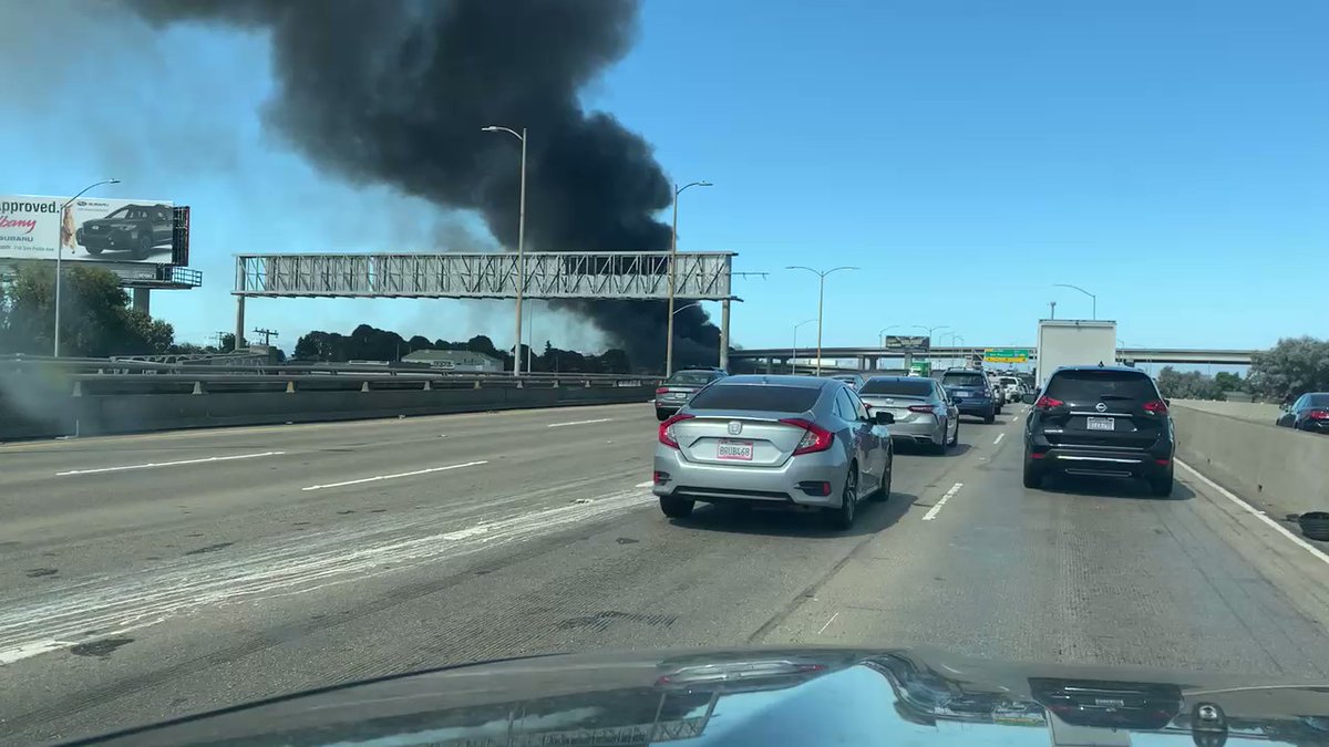 2-alarm fire at encampment near 34th & Wood in West Oakland has sent thick black smoke across area. Numerous RVs &amp; possible train trestle on fire, per @OaklandFireLive @OaklandFireCA. @CHPoakland on scene on affected MacArthur Maze overpasses