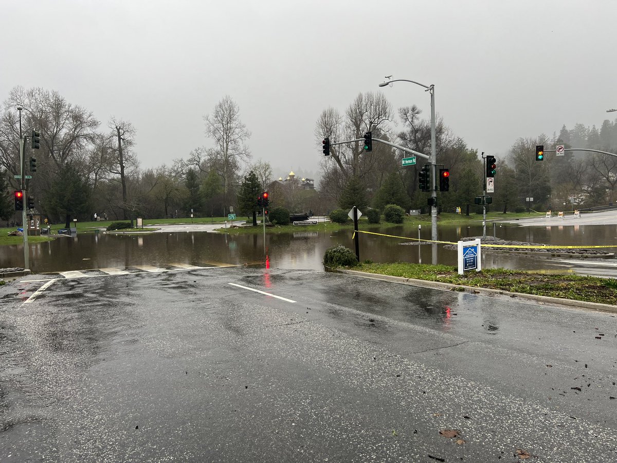 Santa Cruz County in the San Lorenzo Valley area. Notice the floodwaters waters taking over this intersection. People are standing around. It's dangerous