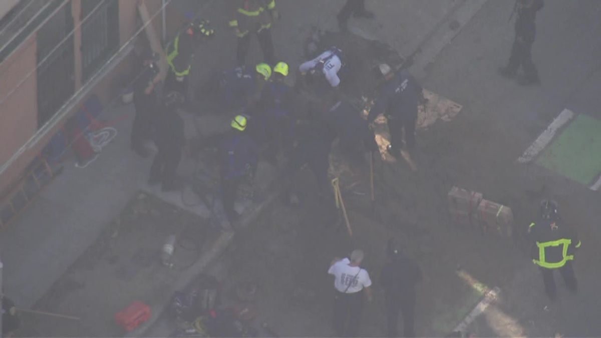 San Francisco firefighters are attempting to rescue a person who is trapped under an estimated 8 feet of dirt, the department said