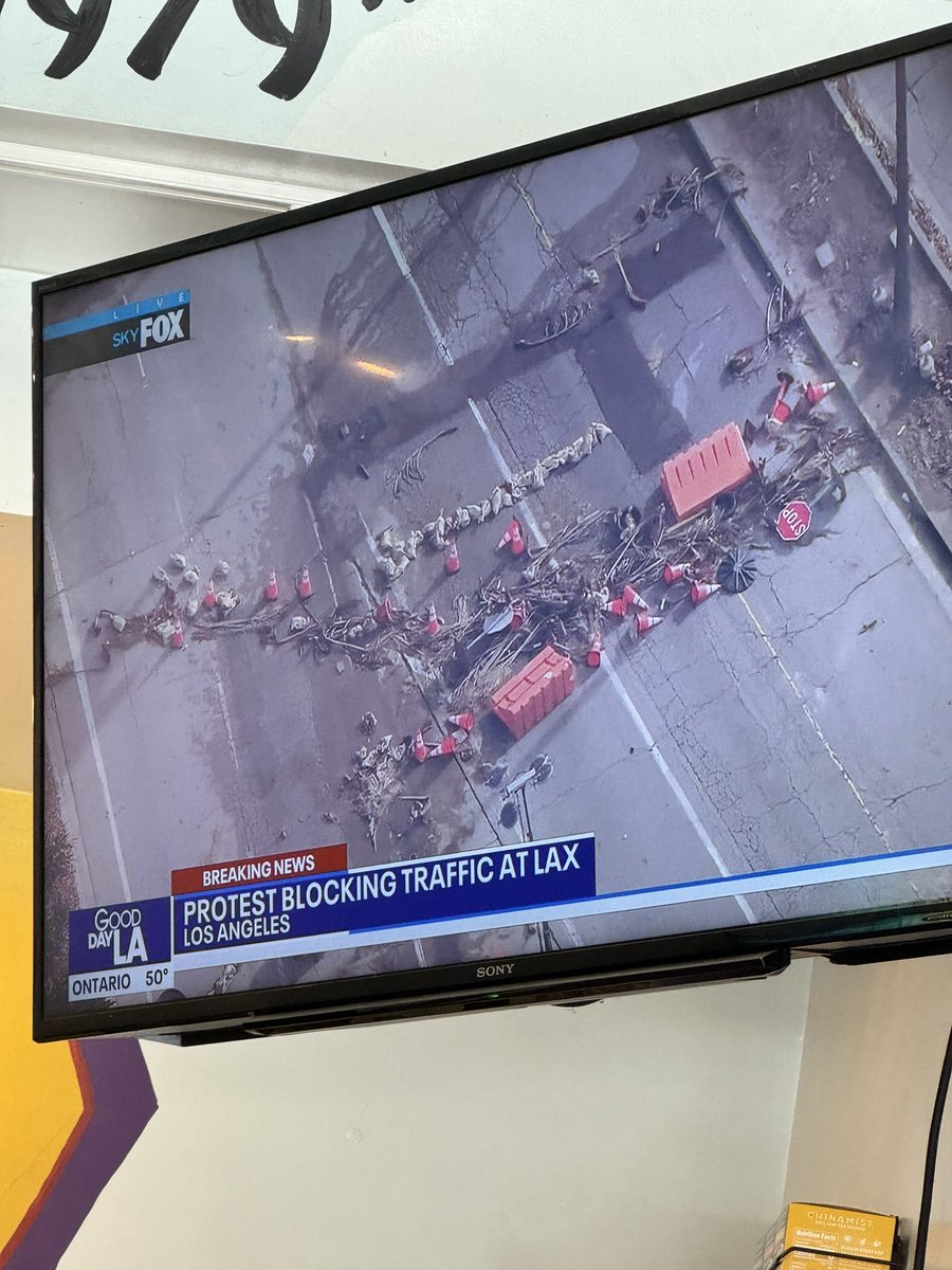 Protesters blocking traffic into LAX  - they pulled barricades into the streets to block cars. @FOXLA chopper above it now - it looks like police are retaking control and  chasing the protesters away