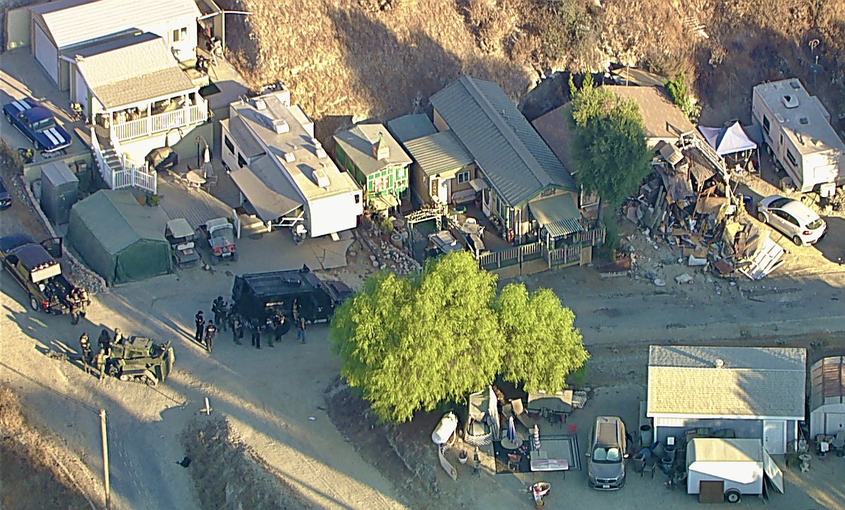 Riverside County Sheriff's SWAT team is at the Olive Dell nudist ranch in Redlands, CA searching for a  person of interest  in the disappearance of an elderly couple. They have breached a neighbor's home of the missing couple and have encountered a major hoarding