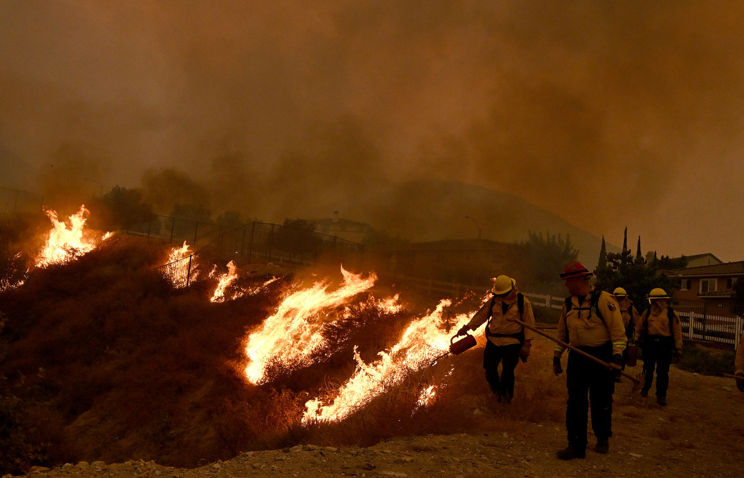 Firefighters try to keep the Line fire away from homes on Emmerton Lane in Highland on Saturday evening Sep. 7, 2024. 