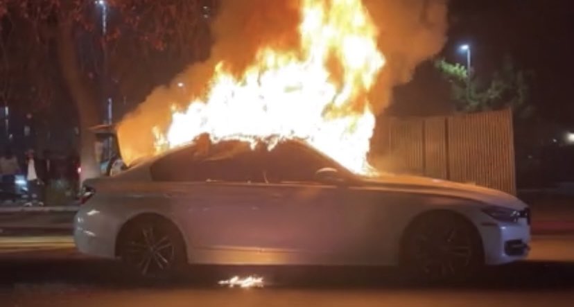 Sideshow at 16th & San Pablo Ave. Cars skate past @OICSharksIce Center & landmark Maclise Drugstore Bldg blocks from @Oakland City Hall. @BMW set on fire. @oaklandpoliceca arrive to disperse participants