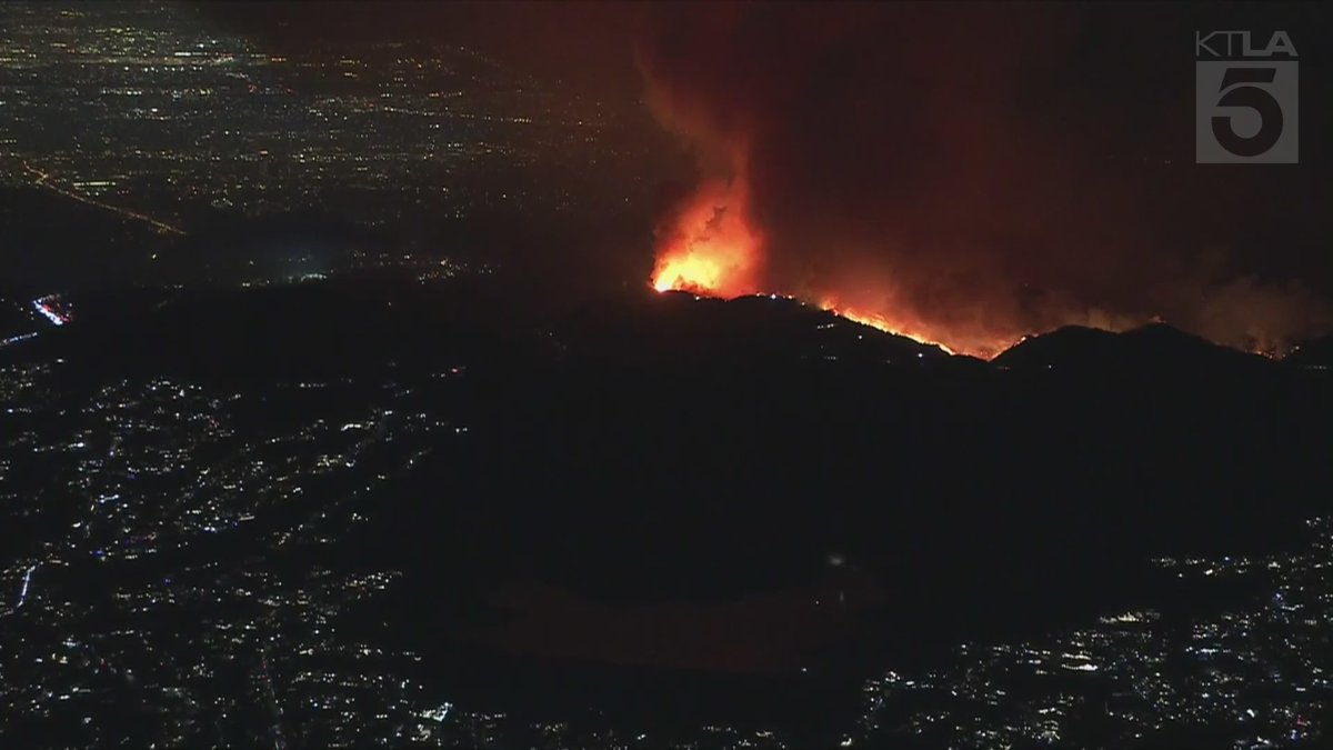 Sky5 is overhead of the northern flank of the Palisades Fire as it burns over the mountains, threatening San Fernando Valley communities.