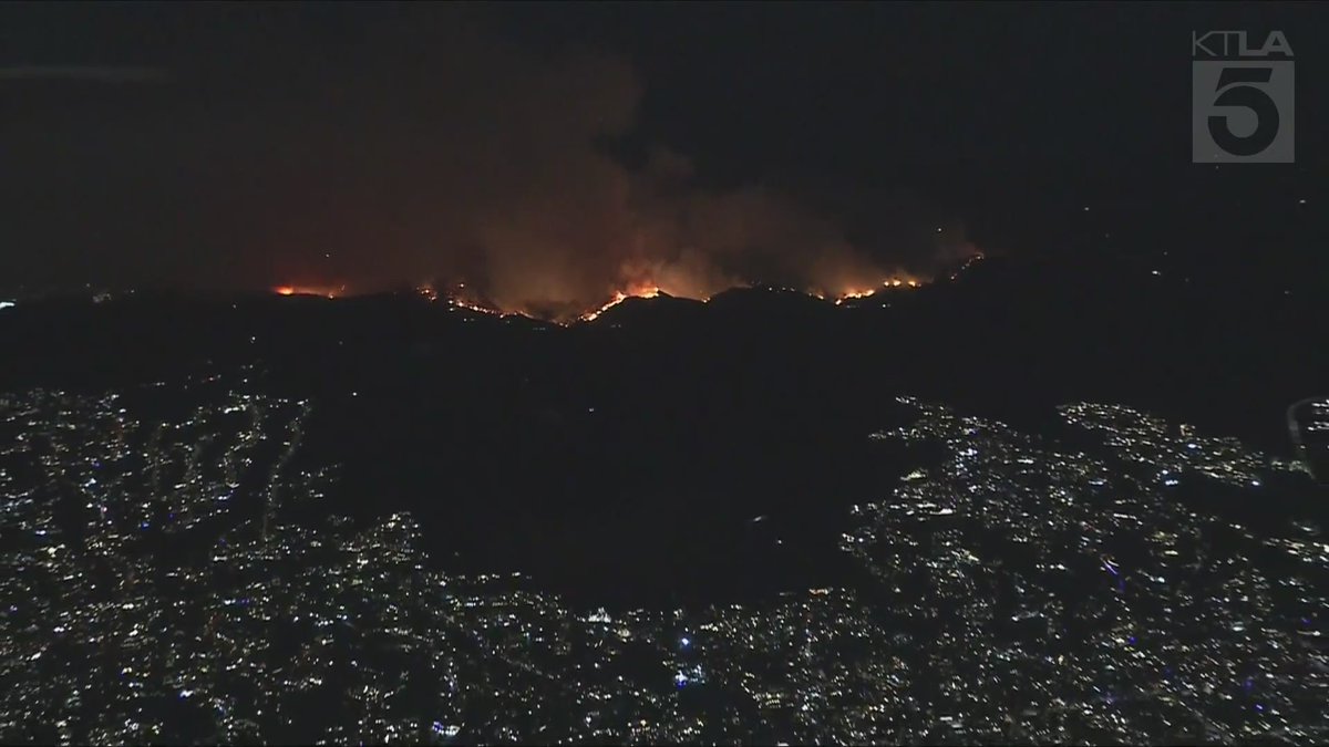 Sky5 is overhead of the northern flank of the Palisades Fire as it burns over the mountains, threatening San Fernando Valley communities.