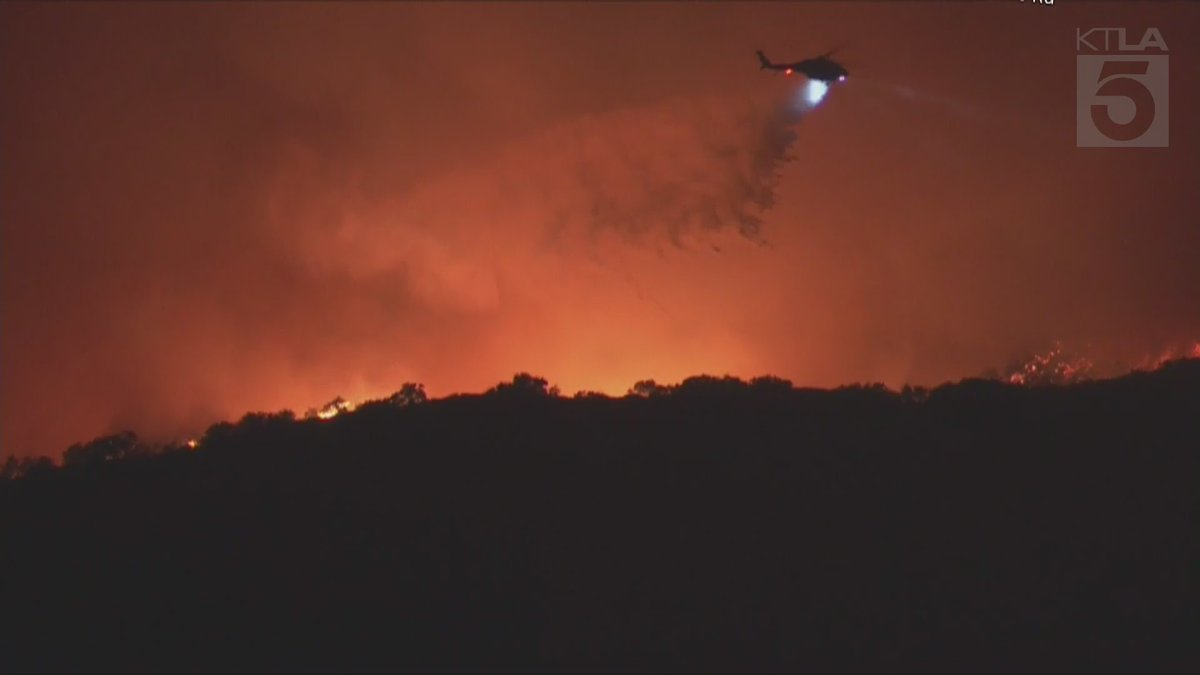 Sky5 is overhead of the northern flank of the Palisades Fire as it burns over the mountains, threatening San Fernando Valley communities.